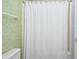 Cozy bathroom featuring a shower with white curtain, light green walls, and floral wall decorations at 5404 Cayman Dr, Carmel, IN 46033