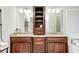 Bathroom with a dual sink vanity with granite countertops, a central storage cabinet, and large mirrors at 5404 Cayman Dr, Carmel, IN 46033