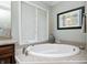 Corner bathtub with decorative faucet sits beneath a window, surrounded by granite countertop at 5404 Cayman Dr, Carmel, IN 46033