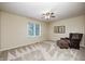 Neutral bedroom featuring a ceiling fan, a window letting in natural light, and patterned chair and ottoman at 5404 Cayman Dr, Carmel, IN 46033