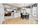 Open dining area with wood floors and windows providing seamless flow to the adjacent living room and kitchen at 5404 Cayman Dr, Carmel, IN 46033