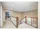 Upstairs hallway with wood railing and carpet, leading to bedrooms with an open view to foyer below at 5404 Cayman Dr, Carmel, IN 46033