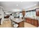 Open kitchen with wood cabinets, granite countertops, and island seating flowing into the living room at 5404 Cayman Dr, Carmel, IN 46033
