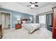 Relaxing main bedroom featuring a tray ceiling, soft blue walls, neutral carpet and ensuite bathroom at 5404 Cayman Dr, Carmel, IN 46033