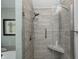 Bathroom shower with stylish tile, glass doors, a built-in seat, and modern fixtures at 5404 Cayman Dr, Carmel, IN 46033