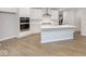 Stylish kitchen features white cabinets, stainless steel appliances, a spacious island, and wood flooring at 569 Dalton Way, Avon, IN 46123