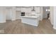 An open kitchen features white cabinets, stainless appliances, a large island, and flows into the living area at 569 Dalton Way, Avon, IN 46123