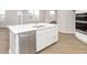 A kitchen island features a stainless steel dishwasher, white cabinets, and quartz countertop at 569 Dalton Way, Avon, IN 46123