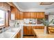 Kitchen features natural wood cabinetry, white appliances, and a view into the dining room at 5905 N County Rd 600 E, Brownsburg, IN 46112