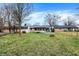Lush backyard featuring a screened-in porch, mature trees, a fire pit and storage shed at 634 Park Dr, Greenwood, IN 46143