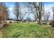 Large backyard with mature trees, lush grass, and a screened-in porch at 634 Park Dr, Greenwood, IN 46143