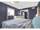 A bedroom with blue walls, a window, and a large mirror closet door at 634 Park Dr, Greenwood, IN 46143