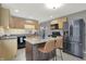 A kitchen featuring stainless steel appliances, tile backsplash and an island with granite countertop and seating at 634 Park Dr, Greenwood, IN 46143
