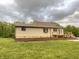 Home's backyard features a spacious lawn and a wooden deck, perfect for outdoor gatherings at 6593 N 800 W, Elwood, IN 46036