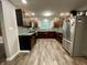 Spacious kitchen featuring stainless steel appliances, dark wood cabinets, and hardwood floors at 6593 N 800 W, Elwood, IN 46036