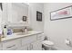 Bright bathroom featuring white vanity, sink, toilet and framed prints on the neutral wall at 6760 Spirit Lake Dr # 11, Indianapolis, IN 46220