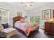 Bedroom with colorful quilt, hardwood furniture and chair and window at 6760 Spirit Lake Dr # 11, Indianapolis, IN 46220