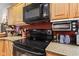 Modern black cooktop and microwave complement the light wood cabinets, creating a stylish cooking space at 6760 Spirit Lake Dr # 11, Indianapolis, IN 46220