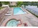 Community pool with hot tub, lounge chairs, and a scenic view of the lake at 6760 Spirit Lake Dr # 11, Indianapolis, IN 46220