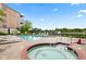 Relaxing community pool with a hot tub, lounge chairs, and a scenic view of the nearby lake at 6760 Spirit Lake Dr # 11, Indianapolis, IN 46220