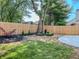 Fenced backyard with a newly installed concrete patio, tasteful landscaping, and mature trees at 6845 Arjay Dr, Indianapolis, IN 46217