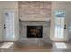 Living area featuring a white painted brick fireplace, hardwood floors, and access to the outdoor patio at 6845 Arjay Dr, Indianapolis, IN 46217