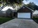 Charming brick home with a two-car garage, mature trees, and a well-maintained lawn at 6845 Arjay Dr, Indianapolis, IN 46217