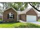 Charming brick home featuring an attached two car garage, well manicured lawn, and attractive landscaping at 6845 Arjay Dr, Indianapolis, IN 46217