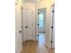 Hallway with multiple white doors and black hardware, with a view into a sunlit room through an open doorway at 6845 Arjay Dr, Indianapolis, IN 46217