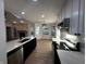 Bright kitchen boasts stainless steel appliances, white cabinetry, an island, and views to the living area at 6845 Arjay Dr, Indianapolis, IN 46217