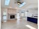 Open concept living area featuring a brick fireplace, skylights, recessed lighting, and patio access at 6845 Arjay Dr, Indianapolis, IN 46217