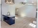 Open concept living space featuring skylights, hardwood floors, and a blue kitchen island at 6845 Arjay Dr, Indianapolis, IN 46217