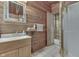 Bathroom with vanity, sink, mirror, and wood walls at 6937 Muskrat Dr, , IN 46164