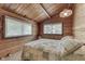 Bedroom with vaulted ceiling, wood walls, and two windows overlooking the yard at 6937 Muskrat Dr, , IN 46164