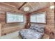 Bedroom with twin beds, wood walls, vaulted ceilings, and windows at 6937 Muskrat Dr, , IN 46164