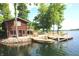 Lakeside cabin featuring a wooden deck and docks, offering direct access to the serene lake waters at 6937 Muskrat Dr, , IN 46164