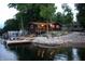 Waterfront cabin featuring docks, landscaping, and a wooden deck, perfect for lakeside relaxation and recreation at 6937 Muskrat Dr, , IN 46164
