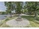 Beautiful waterfront property featuring a stone firepit surrounded by lush greenery and a view of the lake at 6937 Muskrat Dr, , IN 46164