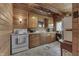 Galley kitchen with wood walls, cabinets, stove, and tile floors at 6937 Muskrat Dr, , IN 46164
