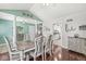 Chic dining area with wood floors, stylish seating, columns, and a view towards a modern kitchen at 7221 State Road 42, Martinsville, IN 46151