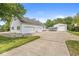 Long concrete driveway leads to a white house with a three-car garage and a separate outbuilding at 7221 State Road 42, Martinsville, IN 46151
