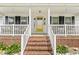 Inviting front porch with brick steps, a white railing, and seating, creating a welcoming entrance at 7221 State Road 42, Martinsville, IN 46151