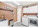 Functional laundry room with front load washer/dryer, tile floor, and overhead cabinets at 7221 State Road 42, Martinsville, IN 46151