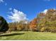 A sprawling backyard features lush grass, mature trees, and blue sky at 7380 N 225 W, Lebanon, IN 46052
