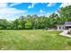 Wide shot of backyard with manicured lawn, trees, in-ground pool, and garden at 7380 N 225 W, Lebanon, IN 46052
