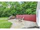 Fire pit and wood storage area with red fence backing up to treeline at 7380 N 225 W, Lebanon, IN 46052