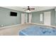 Well-lit bedroom with carpet, ceiling fan, mounted TV, and multiple doorways for easy access at 7380 N 225 W, Lebanon, IN 46052