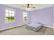 This bedroom is painted lavender with two windows and a ceiling fan at 7380 N 225 W, Lebanon, IN 46052