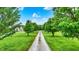 Long gravel driveway leading to a stunning home, framed by lush greenery and a bright blue sky at 7380 N 225 W, Lebanon, IN 46052