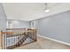Open hallway with carpeted floors and wooden railing, offering a bright and airy transition space at 7380 N 225 W, Lebanon, IN 46052